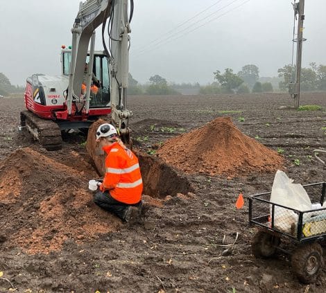 Soil sampling and testing at Chelford Sands with excavator and soil mounds.