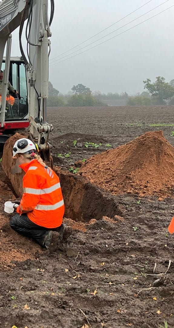 Soil sampling and testing at Chelford Sands with excavator and soil mounds.